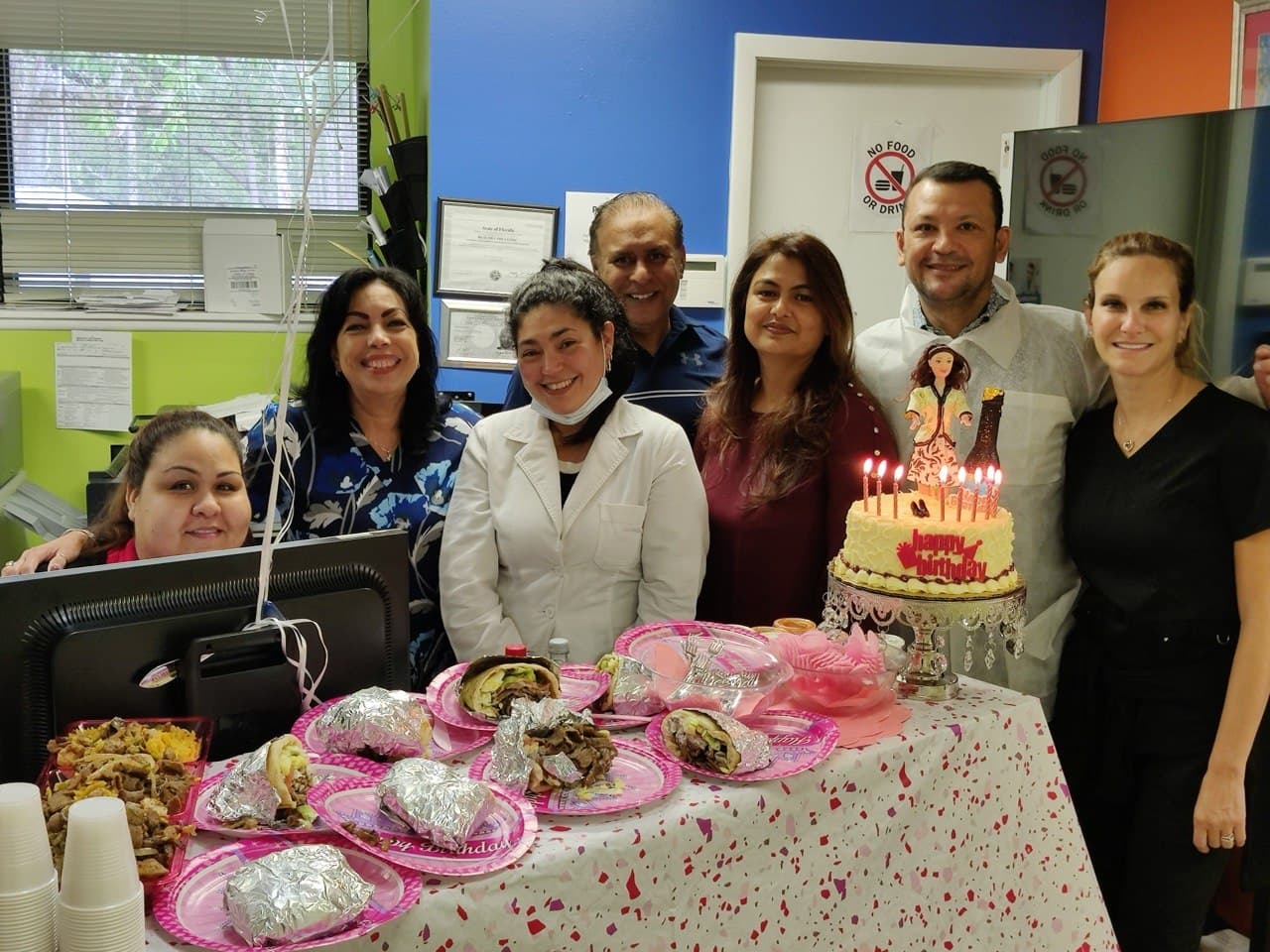 Equipo de Lake Nona Medical Services reunido alrededor de un pastel de cumpleaños