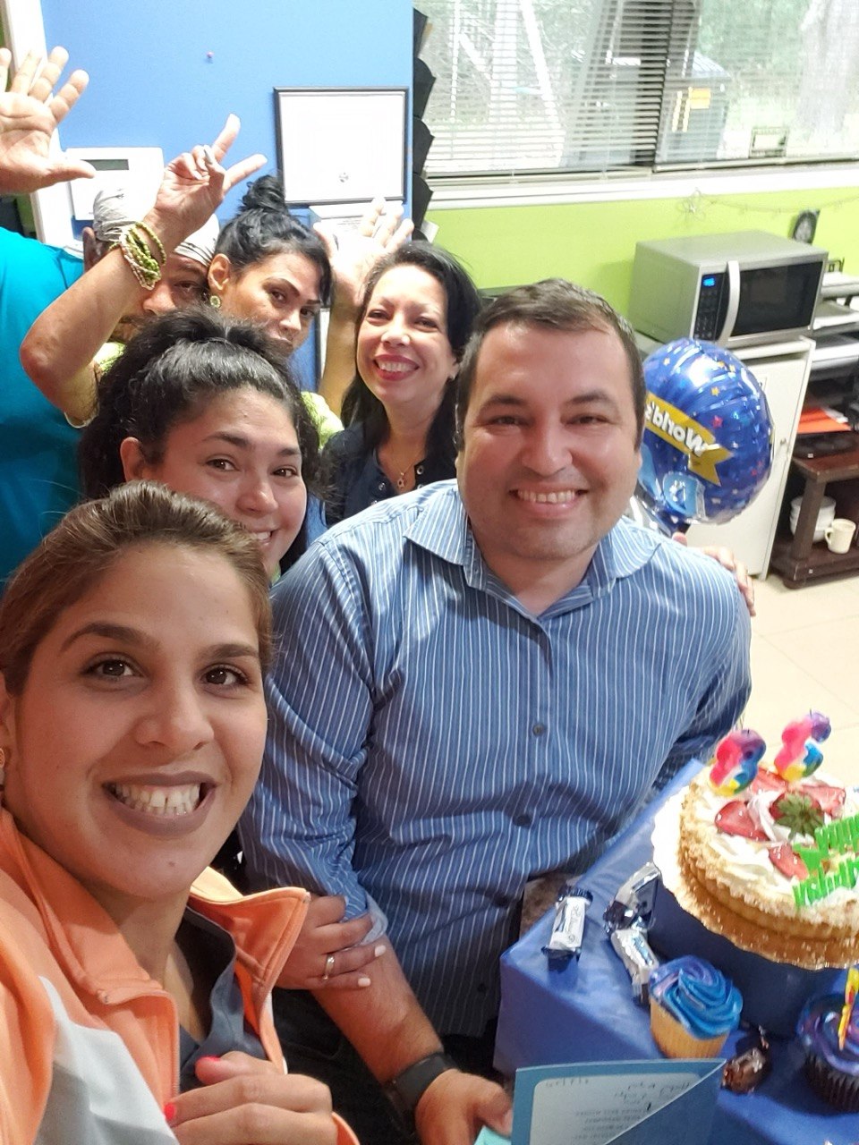 A close, joyful selfie of the Lake Nona Medical team celebrating with a cake